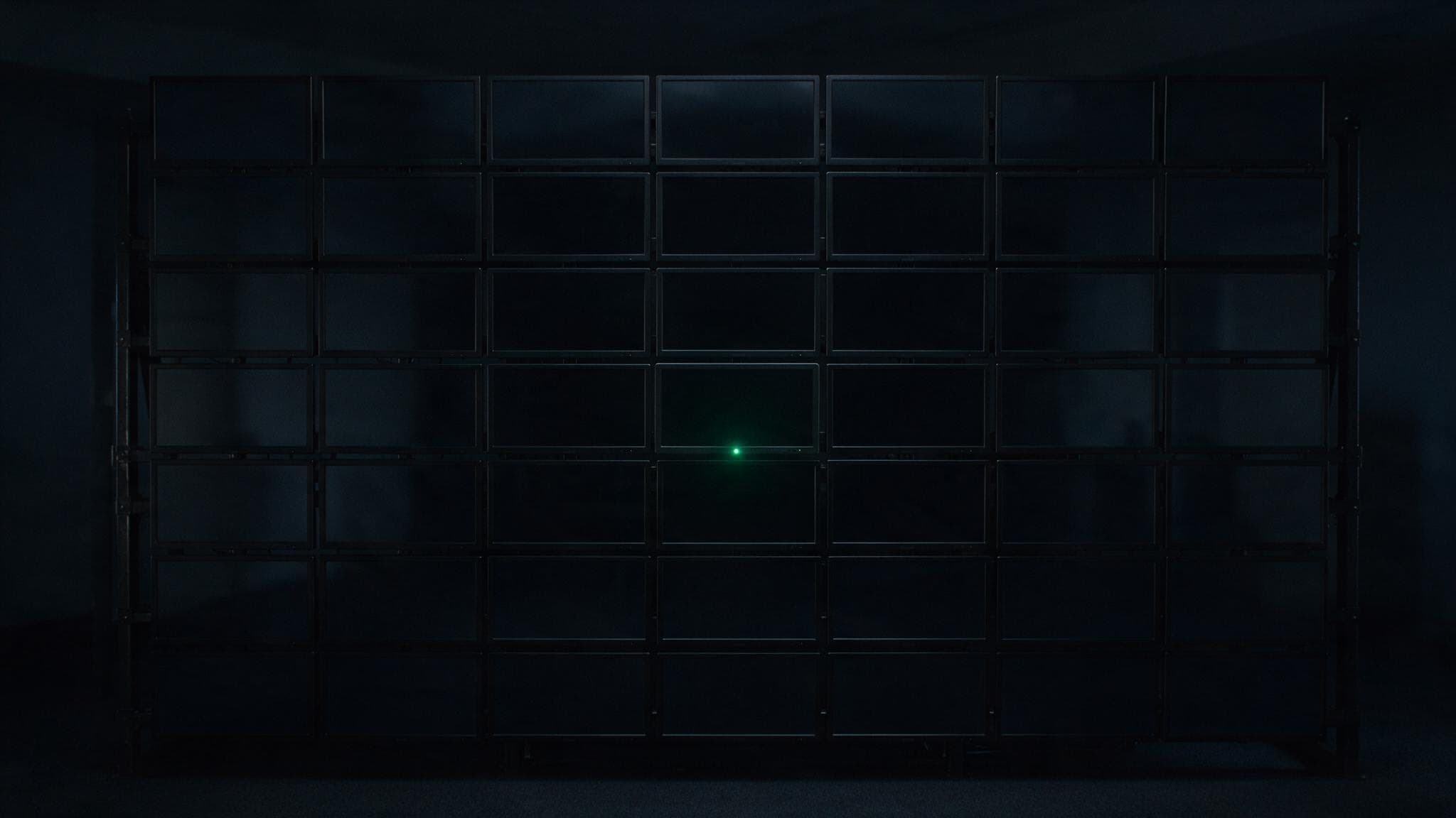 A wall of dormant screens with a single standby light: what "load nothing until consent" actually looks like