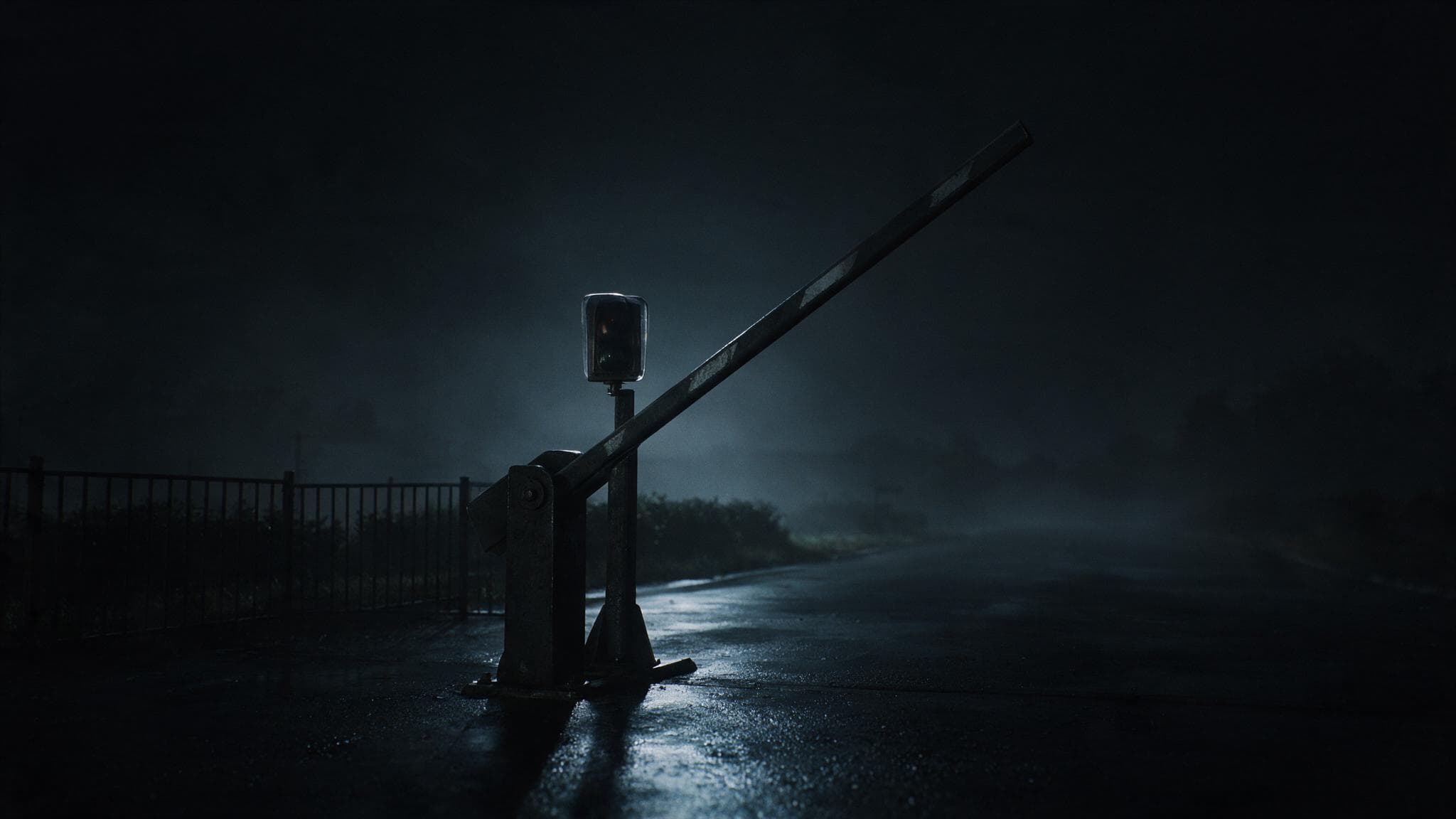 A security barrier standing raised at night with the signal light above it completely dark